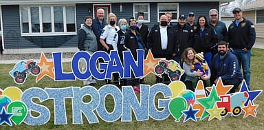 Erin and DJ Olson, kneeling at right with their son Logan, pose for a photo with the first responders who answered the call after Logan fell into a retention pond on April 7. Standing, from left, Molly Hintz and Mike Hintz, Erin Olson's parents and Logan's grandparents; five responders from the Mayo Clinic Ambulance Service, and Stewartville first responders Aaron Jones, Steve Wolf, Bob Robertson, Lisa Jelinek, Greg House and Justin Lonien.