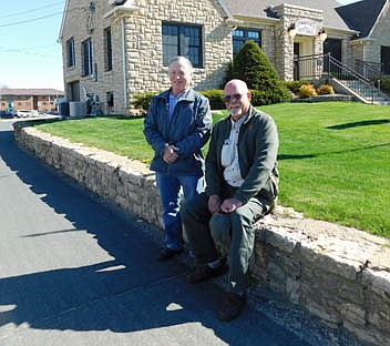 Mayor Jimmie-John King, left, and Buck Fredricksen pose at the soon-to-be replaced retaining wall just west of Stewartville City Hall. King and Fredricksen said the wall, a place where employees of nearby businesses often take work breaks, was installed along with the City Hall building in 1937. Fredricksen is forming a Stewartville Historical Society Facebook group, which already includes more than 40 members.