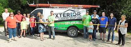 The Stewartville Area Chamber of Commerce welcomed Exterior Cleaning Solutions as a new Chamber member with a ribbon-cutting ceremony at Bear Cave Park on Thursday, July 8. Exterior Cleaning Solutions offers a number of services, including house softwashing, roof cleaning and treatments, and window and gutter cleanng. Keenan Kolstad, owner of the business, with the scissors in the front row, cuts the ribbon to celebrate the occasion. Also in the front row, from left, holding the ribbon, are Gwen Ravenhorst, Chamber administrator; Myrna Welter, Chamber membership coordinator, and Ann Lutteke, Chamber member from ONB Bank. Back row, from left, Bill Schimmel Jr., city administrator; Dave Hildebrandt of Hildebrandt Services LLC & Rain Control Seamless Gutters LLC; Emily Bredesen (foreground), Andrea Bredesen holding Isaac Bredesen, Matt Bredesen, Ellie Horvie, Matt Jacobs, Emery Kruger (foreground), Ed Kruger of EZ Camper Rentals, Michelle and Cody Moe of Flowers & More, and Kevin Welter of Welter Entertainment.