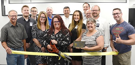 The Stewartville Area Chamber of Commerce welcomed Tulip Tree Studios as a new Chamber member with a ribbon-cutting ceremony on Wednesday, July 14. Tulip Tree Studios provides creative marketing and design solutions to help local businesses stand out through results-driven marketing efforts. Whitney West, owner of Tulip Tree Studios, with the scissors in the front row, cuts the ribbon to celebrate the occasion. Also in the front row, from left, are Al Chihak of R&C Storage, Myrna Welter, Chamber membership coordinator, and Jared Johnson of Halcon, Chamber president. Second row, from left, are Brian Flacky, Crystal Landherr, Claire Kingsley and Jeff Sadler, all of Tulip Tree Studios. Back row, from left, are Chamber members Kevin Welter of Welter Entertainment, Bill Schimmel Jr., city administrator; Troy Knutson of Edward Jones, Nick Johnson of Thrivent Financial and Ty Bestor of Valor Mechanical. Tulip Tree Studios is located in the Valor Mechanical building across the street from and just west of 2 Brothers Bar & Grill.
