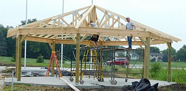 Workers are making steady progress on the new Veterans Memorial Park near Stewartville's south entrance. Volunteer workers, such as those pictured above, have installed trusses for the octagon picnic shelter and are working on the building's roof.