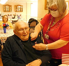 The Stewartville Care Center honored its seven military veterans at a Veterans Day ceremony on Thursday, Nov. 11. Above, Richard Wittlief, who served in the U.S. Air Force during the Korean War, receives a pin from Rita Christian, activities assistant at the Care Center.