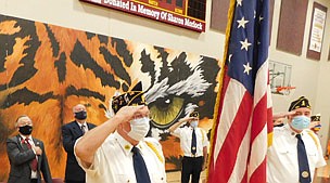 Members of the Stewartville American Legion Post 164 salute the flag while standing at attention during the playing of the National Anthem at the annual Veterans Day ceremony at the Stewartville High School gym on Thursday, Nov. 11. Legion members, from left, include Dave Nystuen, Commander Ron Moore and Bill Hurley. Standing from left in back are Mayor Jimmie-John King and Bill Schimmel Jr., city administrator, guest speakers at the ceremony.