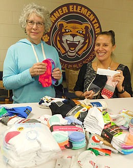 Carol Youdas, chair of the Stewartville Kiwanis Club's Sock It To 'Em Sock Drive, left, delivered some of the socks the Club collected to Courtney Fakler, school social worker, at Bonner Elementary School last week.