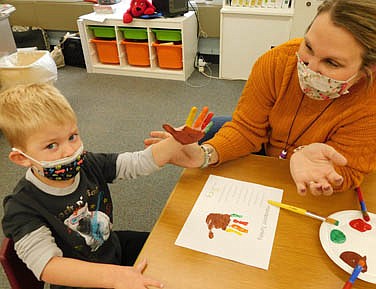 2021 review -- Joey Breen, 3, assisted by Nashia Baldus, early childhood teacher, displays a turkey imprint on his hand and the printed page at the Central Education Center on Thursday, Nov. 18.
