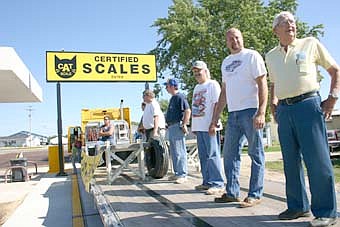 TIPPING THE SCALES -- Ten members of the Racine Lions Club added their weight to a tractor-trailer at Racine Travel Plaza on Saturday morning, July 21. Laura Irlbeck of Racine won a $500 prize for coming closest to guessing the total weight of men and machine, which came to 33,300 pounds.  The men weighed a total of 2,200 pounds.  
