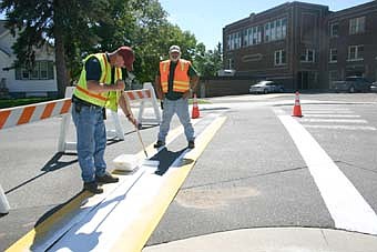 PREPARING FOR SCHOOL -- Brian Montgomery, left, and Dan Harris, city of Stewartville public works employees, painted a new crosswalk near Central Intermediate School last week. Students will start walking between the lines in large numbers on Tuesday, Sept. 4, the first day of school. 