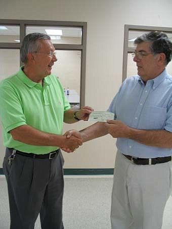George Sedgwick is presenting a check from Kiwanis to Dave Nystuen for student school supplies.  