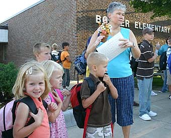 SCHOOL DAYS -- Karen Moen, center, and her Tiger Time Early Childhood students wait for the bus to take them from Bonner Elementary School to Central Intermediate School on the first day of school last week. Students include, from left, Abby Manthei, Tessa Lanzel and Bryce Rindels.  