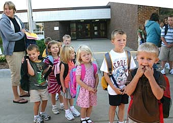 HEADED BACK TO SCHOOL -- Erin Olson, far left, and her Tiger Time Early Childhood students wait for the bus to take them from Bonner Elementary School to Central Intermediate School on the first day of school last week. Students include, from left, Ben Trenary, Kendall Clausen, Abby Manthei, Tessa Lanzel, Trent Einertson and Bryce Rindels.  
