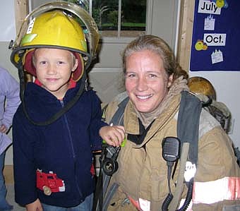 Stewartville Child Care Center received a visit from members of the Stewartville Fire Department last week during Fire Prevention Week. Pictured  is Zeke Zodrow with firefighter Becky Teal.   