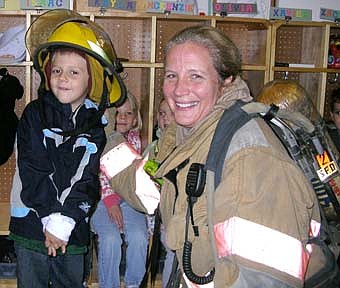 Pictured is Ian Hoot, wearing a fire hat and posing with Becky Teal, Stewartville Fire Fighter. 