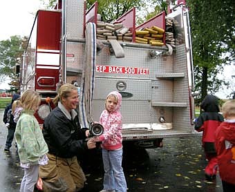 McKenzie Boehm is on the left while firefighter Becky Teal is showing Kayla Stevens the water hose on the right. Kids from the Stewartville Child Care Center received a visit from members of the Stewartville Fire Department last week in observance of Fire Prevention Week. 