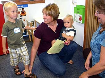 Scores of students accompanied their parents to the annual Wee Care  Open House at St. John's Wee Care on Sunday, Sept. 9. The  open house gives students and their parents a chance to meet teachers and review Wee Care's facilities. Here, Heather Preston holds her 1-year-old son Sidney as another son, 3-year-old Conner, prepares to meet Lori Torgerson, a Wee Care teacher, at right. 
