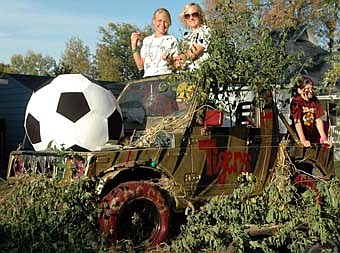 FUN WITH THE FLOAT -- In keeping with the 2007 Stewartville High School homecoming theme, "The Jungle," varsity girls soccer captains Maia Gunderson, left, and Melisa Fischer throw candy from the girls soccer float, a tiger -striped safari jeep, during the homecoming parade on Friday, Sept. 28. 
