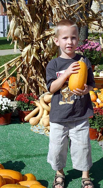 Although the weather felt more like July, hundreds of shoppers enjoyed the annual Fall Harvest Day at the parking lot near Stewartville City Hall on a warm and windy Saturday, Oct. 6. Here, Jack Parry, 5, of Stewartville, grasps the spaghetti squash he has so carefully selected. 