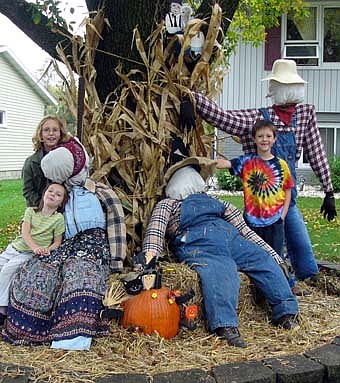 Kids Will Be Kids Daycare children pose with a scarecrow they helped disply. From left are, Kelsey, Kayla, and Ethan. 