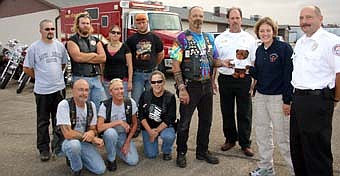 BEARS FOR THE CHILDREN -- Stan Rygh, president of the Lower Corner Minnesota Chapter of ABATE (American Bikers for Awareness, Training and Education), standing fourth from right, presents a Buddy Bear to representatives of the Stewartville Fire Department on Sunday, Oct. 7. Firefighting officials who accepted the 24 Buddy Bears include Ike Duncan, assistant fire chief, third from right; Lisa Jelinek, first response director, and Steve Wolf, fire chief, far right. Stewartville firefighters will share the bears with children seeking comfort after a fire. Members of the Lower Corner Minnesota Chapter of ABATE include, kneeling from  left, Bill Marx, Angie Jacobi and Becky Diderrich. Standing in back, from left, Gump, Steve Meyerhofer, Melissa Dudley and Jason Dudley.  The Lower Corner Chapter of ABATE has been in existence  since 1989. It has 220 members, including doctors and lawyers, Rygh said. ABATE has 2,700 members across the state of Minnesota, he said. 