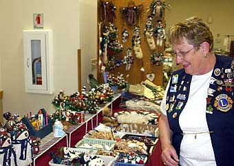  Kay Tvedt of Stewartville  reviews the items available at Karen's Krafts and Kalligraphy of Chatfield.  The craft show and bake sale is a major fund-raiser for Stewartville's senior citizen programs. 