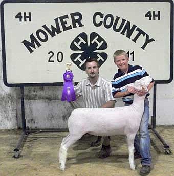 Brock Erickson, a member of the Racine Ramblers 4-H Club did well during the Mower County Fair.  Brock is shown with his Champion White Face Market Lamb. With Brock is Eric Kinsley, judge.  