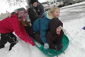 As Erin Jezierski, left, pushes, Olivia Nicklay, on bottom, and Ellie Fryer prepare for the trip down the snow-covered hill at Central Intermediate School last Tuesday, Jan. 24. 