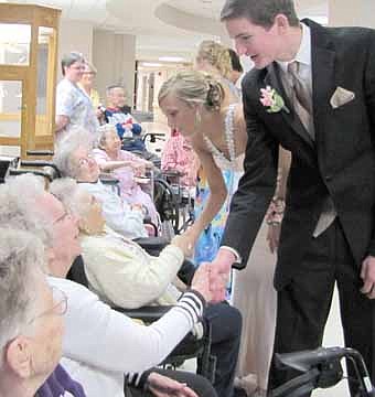 Stewartville High School students dressed for this year's prom visited the Stewartville Care Center on Saturday, April 21. Students Spencer Wright, in the foreground, and Sarah Schrandt shake hands with the Care Center residents. 