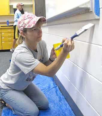  Dawn Clark of Stewartville, above, joined by her son Ryan, 14, in the background, painted a classroom at Stewartville High School during the first annual Stewie Serves event on Saturday, June 16. 