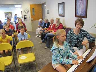 Suz Eberle, piano teacher, far right, watches as MicKenzie Doherty plays during a recital at the Stewartville Care Center on Friday, July 27 