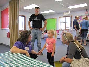 Lori Torgerson, a Wee Care teacher, left, welcomes Keely Hinkle, 3, to Wee Care's annual open house on Sunday, Sept. 9. Keely was joined by her dad, Kyle, standing at left, and her mom, Lacy, right. Keely is looking forward to attending classes at Wee Care, Lacy said. "I like the faith-based preschool education," she said.                                      