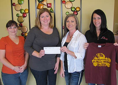 Chris Dahle, owner of Identity Designs of Stewartville, second from right, presented a check for $966 to Carrie Anderson, president of BACPAC (Bonner and Central Parent Advisory Committee) last week. Identity Designs made homecoming T-shirts that were sold to students at Bonner, Central and Stewartville Middle School. One dollar from the sale of each shirt was donated to BACPAC, which typically uses donated money to pay for field trips or supplies for students.  A number of local businesses donated money to help pay for the shirts. Ashley Jones of Identity Designs, far right, designed the T-shirts. Jennifer Hruska, treasurer of BACPAC, is at far left.                                                                                            