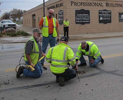 Public works employees from the city of Stewartville tended to a broken water main on Main Street near the Professional Building on Tuesday, Oct. 16. Below, water bubbles up from near Main Street just south of C&M Screen Printing. Workers include, clockwise from left, above, Scott Priebe, Eric Domino, Owen Sass and Sean Hale. Zak Breitenbach, Stewartville's community oriented policing (COPS) deputy, is standing in the background. Mark Stevens, public works director, said that the main broke when water put pressure on the corroded bolts that held the main together.  "The water pressure blew the top off," Stevens said. "We caught it when it happened right away. The loss of water wasn't that bad."  It didn't take workers long to fix the main with new gaskets and bolts, Stevens said. "When they blacktop the streets in the southeast part of town, we'll blacktop the area where the main broke," Stevens said.   