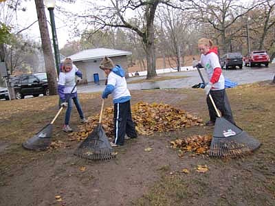 Girl Scouts, from left, Erin Ross, a seventh grader; Olivia Nicklay, a sixth grader; and Lauren Horstmann, a seventh grader,  rake leaves at Florence Park to celebrate the Girl Scouts Centennial Day of Service on Saturday, Oct. 13.       