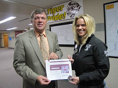 Beth Schmidt accepts a Tiger Token for her service to Stewartville schools from Dr. David Thompson, superintendent. 
