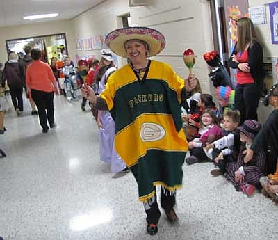 Bonnie Rindahl, a special education paraprofessional, wears a Green Bay Packer blanket and a Mexican hat.