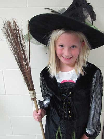 Kylie Westrum, a first grader, dresses as a witch with her broomstick.  