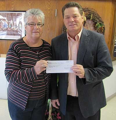Patty Stensrud of Stewartville, left, hands a check for $3,000 to Gene Gustason,  administrator of the Stewartville Care Center. The money will be used toward the purchase of a new van for Care Center residents. Stensrud applied for the funds from the IBM Community Grant program. To be eligible for the funds, she put in many hours of volunteer work in the communty.