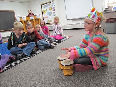 Addelynn Haugen, a kindergartner at Bonner Elementary School, at right, plays the bongo drums to celebrate her birthday in music class at Bonner last week. Lara Smoley, Bonner's music teacher, is standing behind the piano in the background. 