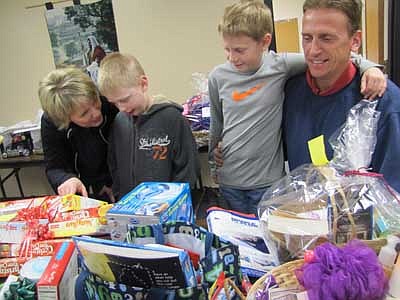 Tim and Kathy Griffin of Rock Dell and their sons, Christopher, 8, a second grader at Bonner Elementary School, and Adam, 10, a fourth grader at Central Intermediate School,  review the silent auction items at the annual One-Stop Christmas Shop at St. John's Wee Care last week. Proceeds from the auction support Wee Care. 