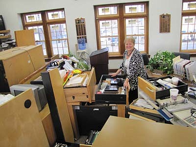  Barb Neubauer, city finance director, stands among the desks, tables, computers and equipment that were moved from employees' offices to the main-floor meeting room as workers installed new windows at Stewartville City Hall last week.