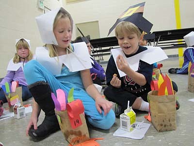 Kendan Grafe, a first grader in Kristine's Rose's class at Bonner Elementary School, right, marvels at what's inside a treat he just opened at the Thanksgiving Feast at Bonner Elementary School on Tuesday, Nov. 20. Kylie Westrum, another student in Rose's class, is at left.    