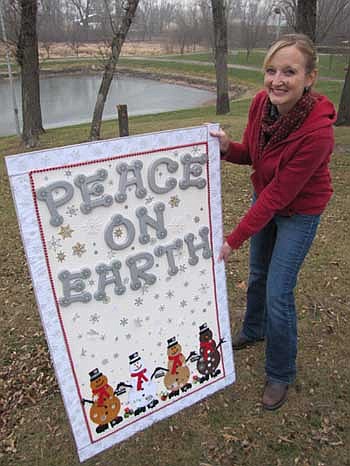 Melissa Sue Martin, administrator of the Stewartville Area Chamber of Commerce, displays a life-sized Christmas card that was included as part of the Chamber's WinterFest celebration at Florence Park on Saturday, Dec. 1. 