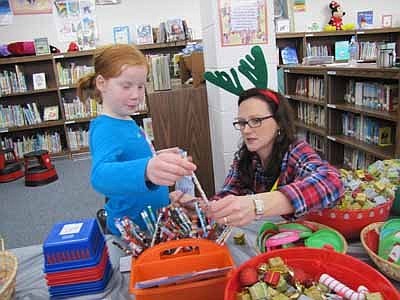 Karley Meyer, 8, a second grader at Bonner Elementary School, gets help from Diane Gray, a parent volunteer, as Karley looks for a gift at the annual BACPAC Santa Shop at Bonner last week. Tina Gordon, a Santa Shop coordinator, said that BACPAC raised $13,700 from last year's Santa Shop. After students and parents bring box tops and bottle caps to school, BACPAC members send the items to Kemps or Kwik Trip, which respond with reimbursement checks. The money pays for Santa Shop items, field trips and more. 