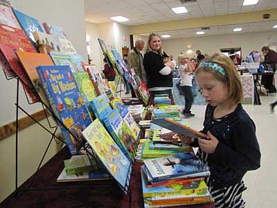 McKenna O'Neill, 6, a first grader at Bonner Elementary School, puts books in alphabetical order at the Usborne Books booth at the Holiday Extravaganza at the Stewartville Civic Center on Sunday, Dec. 2. Nichol O'Neill, McKenna's mom, looks on in the background. "There have been quite a few people," Nichol said. "It has been steady." 