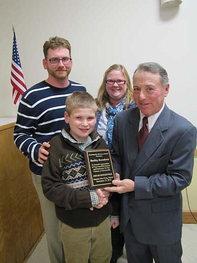 Burkely Ravenhorst, 9, receives the Mayor's Award for Community Service from Mayor Jimmie-John King at the Stewartville Civic Center last week. In back are Burkely's parents, Ryan and Gwen Ravenhorst.