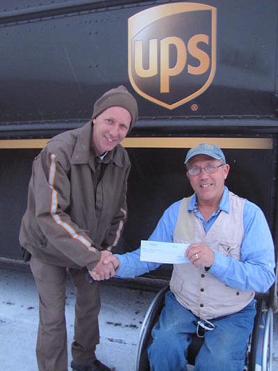 Bob Bardwell, director of Ironwood Springs Christian Ranch, right, accepts a $5,000 donation check from Casey Berg, UPS&#8200;driver, last week. The UPS Foundation, supported by grants from UPS, donated the money. Ironwood Springs will use the funds to help pay for audio equipment, a wheelchair-accessible mini-golf course and Ironwood's National Wheelchair Sports Camp, Bardwell said.