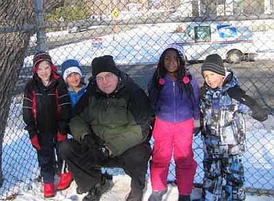 Mark Peterson spends time on the playground with Central kindergartners, including, from left, William Kundert, Jamal Aden, Kamora Jackson and Kayden Tix.   