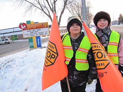 Marshall Pietrzak, left, and Ella Quam, third graders at Bonner Elementary School, worked as School Patrol crossing guards near the school last Thursday morning, Jan. 10. Both said they enjoy their duties. "It's fun," Marshall said. "You get to help other people cross. I'm here once every five weeks and other people are here on different weeks."&#8200;Ella, asked what she likes about the job, said, "(I like it) that we're helping other people cross the road." 