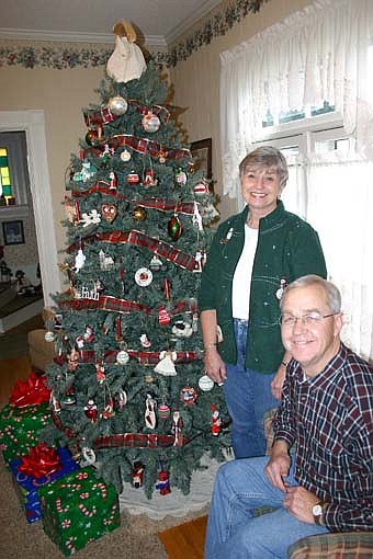 NO PLACE LIKE HOME -- Roger and Kris Wiltgen, 304 Third Street Southwest, pose near the Christmas tree inside their 109-year-old home, which was built in 1898 and has had only three owners, including Jay and Martha Benedict, Curt and Donna Reiser and the Wiltgens. Jay Benedict purchased the home from the lumber company that originally built it. 
