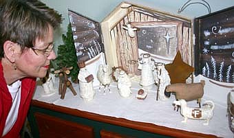 MANGER SCENE -- Shirley Carlson enjoys a closeup look at a Nativity scene inside her historic home at 601 Sixth Street Southwest. The Carlson home will be one of five featured during this year's Friends of the Library Holiday House Tour, to be held this Saturday, Dec. 1 from noon to 4 p.m. Proceeds from the event will benefit the Stewartville Public Library. 