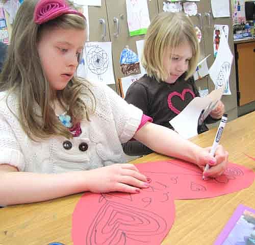 Reese Glynn, left, and Jayda Ramaker, students in Roberta Lentz's kindergarten class at Bonner Elementary School, work on their projects in Laura Moon's art class on Valentine's Day last Thursday, Feb. 14. Students used paper, crayons, scissors, glue and more to design their many unique valentines. 
